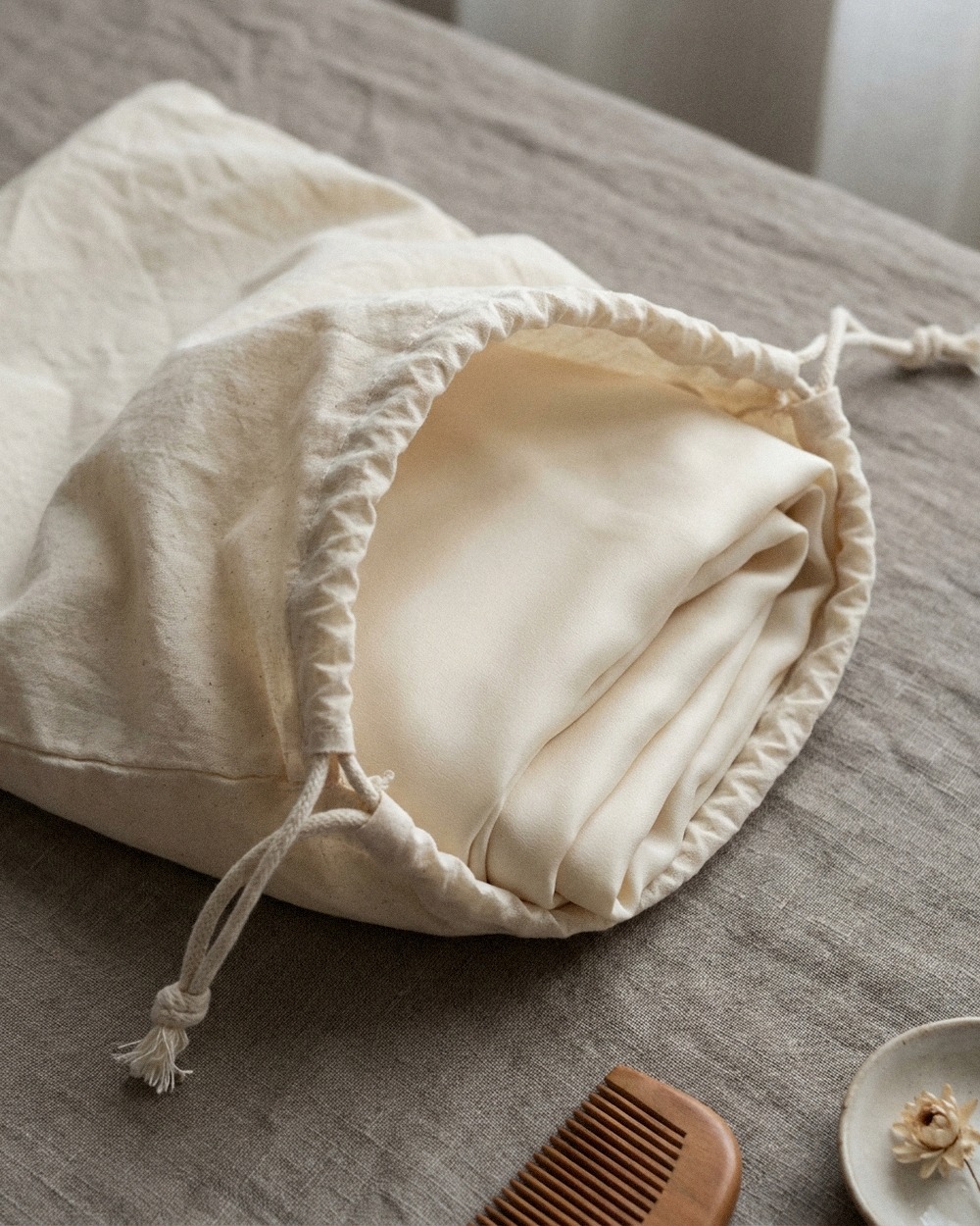 A folded Lannée hijab resting in its cotton dust bag